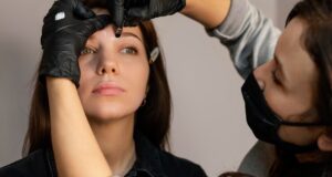 front-view-woman-getting-eyebrow-treatment-from-clinician_23-2148845995